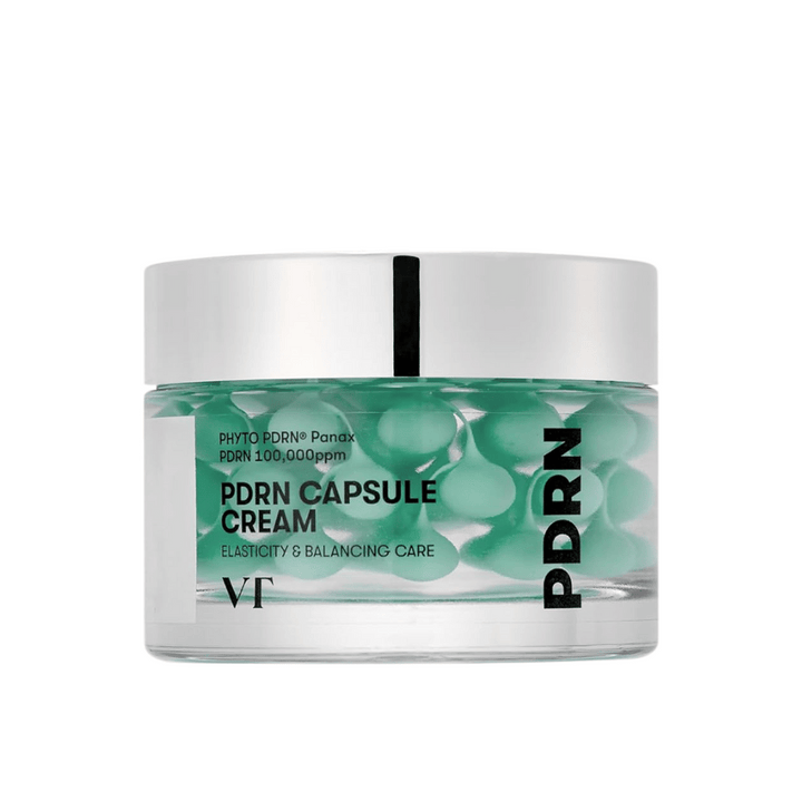 VT PDRN Capsule Cream i en transparent burk med silverlock. Innehållet består av gröna kapslar i en klar gel, och etiketten visar att krämen är avsedd för elasticitet och balanserande hudvård.