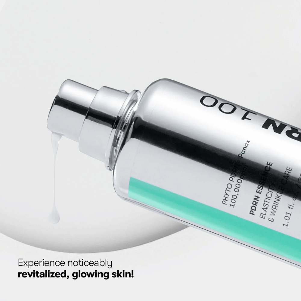 Närbild på en silverfärgad pumpflaska med VT PDRN Essence 100. En vit essens rinner ut från munstycket, och texten på bilden lyder: "Experience noticeably revitalized, glowing skin!"
