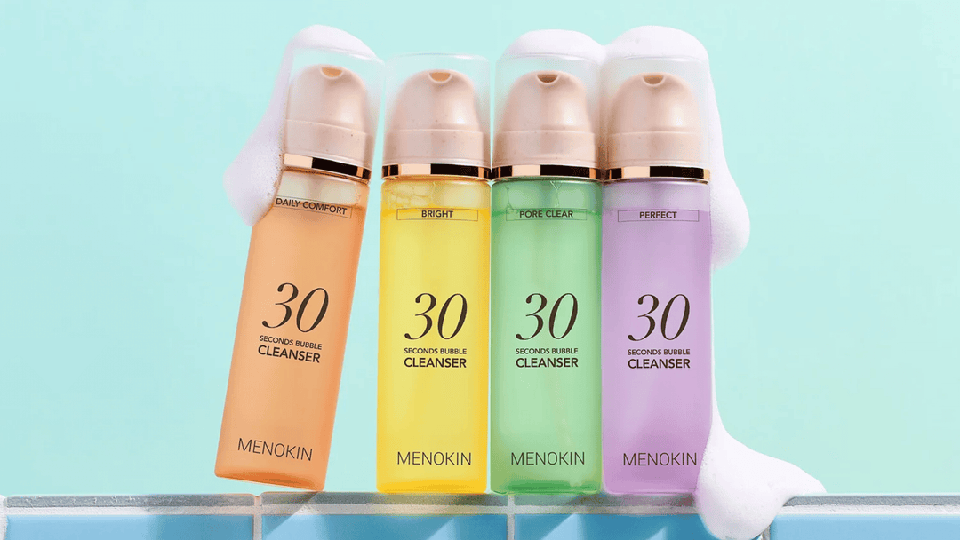 Produktbild som visar fyra varianter av MENOKIN 30 Seconds Bubble Cleanser i olika färger och funktioner: Daily Comfort, Bright, Pore Clear och Perfect. Produkterna står på kaklad yta med mjukt lödder för att framhäva den skummande rengöringen.