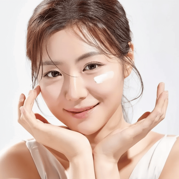 Frau trägt Round Lab 1025 Dokdo Eye Cream unter den Augen auf für Feuchtigkeit, Ausstrahlung und einen ebenmäßigeren Hautton