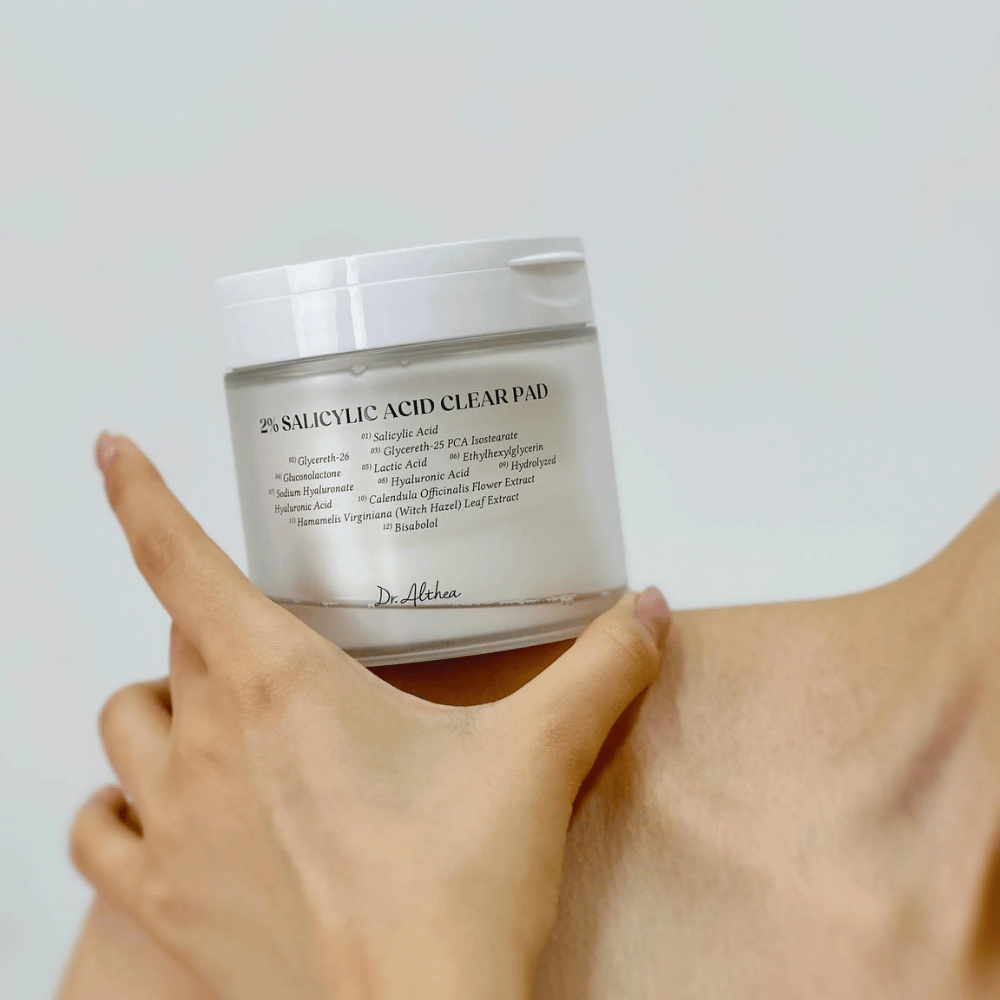 Dr. Althea 2% Salicylic Acid Clear Pad wird in der Hand gehalten. Toner-Pads mit 2% Salicylsäure, die sanft exfolieren, die Haut beruhigen und die Hautstruktur verbessern.