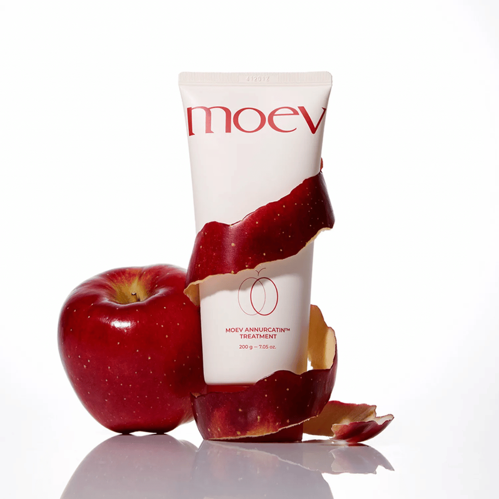 MOEV Annurcatin Treatment zusammen mit roten Äpfeln – symbolisiert die natürliche Kraft des Annurca-Apfels, der das Haar tiefenwirksam pflegt und schützt.