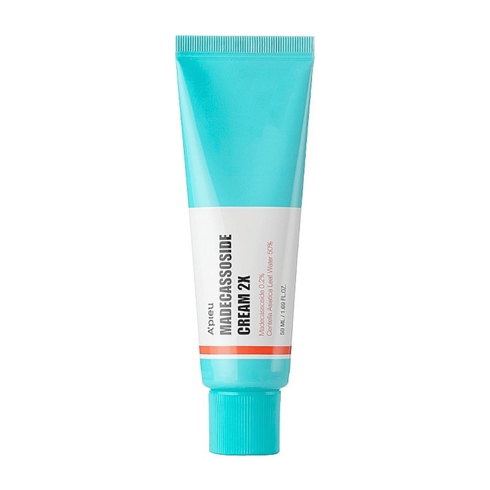 Eine Tube mit A'PIEU Madecassoside Cream 2X, mit einer helltürkisen Farbe oben, die nach unten hin in Weiß übergeht. Die Tube hat deutlichen Text, der Marke und Produktname sowie den aktiven Inhaltsstoff Madecassoside 2% angibt. Eine orangefarbene Akzentfarbe verläuft als Streifen um die Tube. Das Produkt scheint eine Hautcreme zu sein, die auf Hautpflege und -reparatur ausgerichtet ist. Der Hintergrund ist neutral gehalten, um den Fokus auf das Produkt zu lenken.