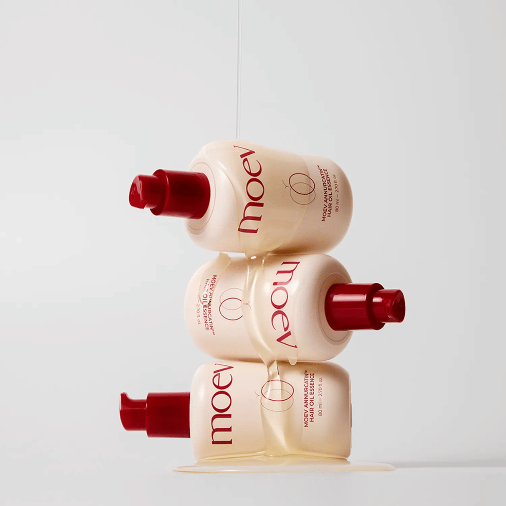 Drei Flaschen MOEV Annurcatin Hair Oil Essence gestapelt – nährstoffreiches Haaröl mit Annurca-Apfel und Biotin, das stärkt, schützt und dem Haar Glanz und Elastizität verleiht.