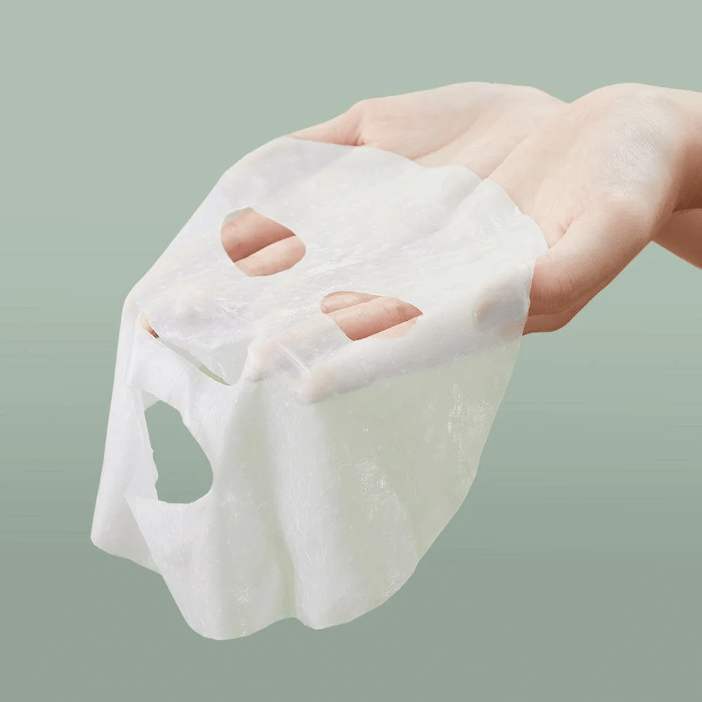 Eine Hand einer Person, die Anua Heartleaf 77% Soothing Sheet Mask hält.