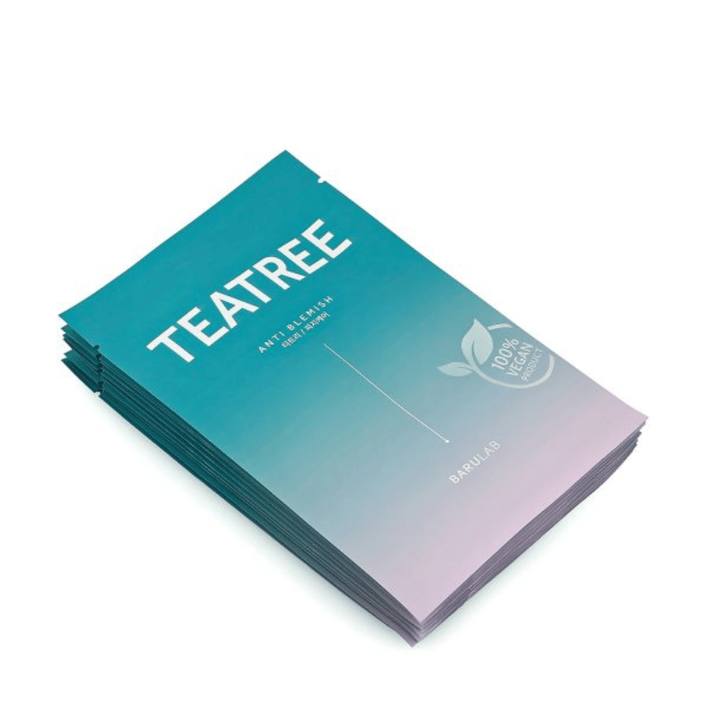 Ein Stapel von Verpackungen der BARULAB "TEATREE Anti Blemish" Masken, alle gekennzeichnet als "100% Vegan Product". Die Verpackungen haben eine einheitliche türkise Farbe.