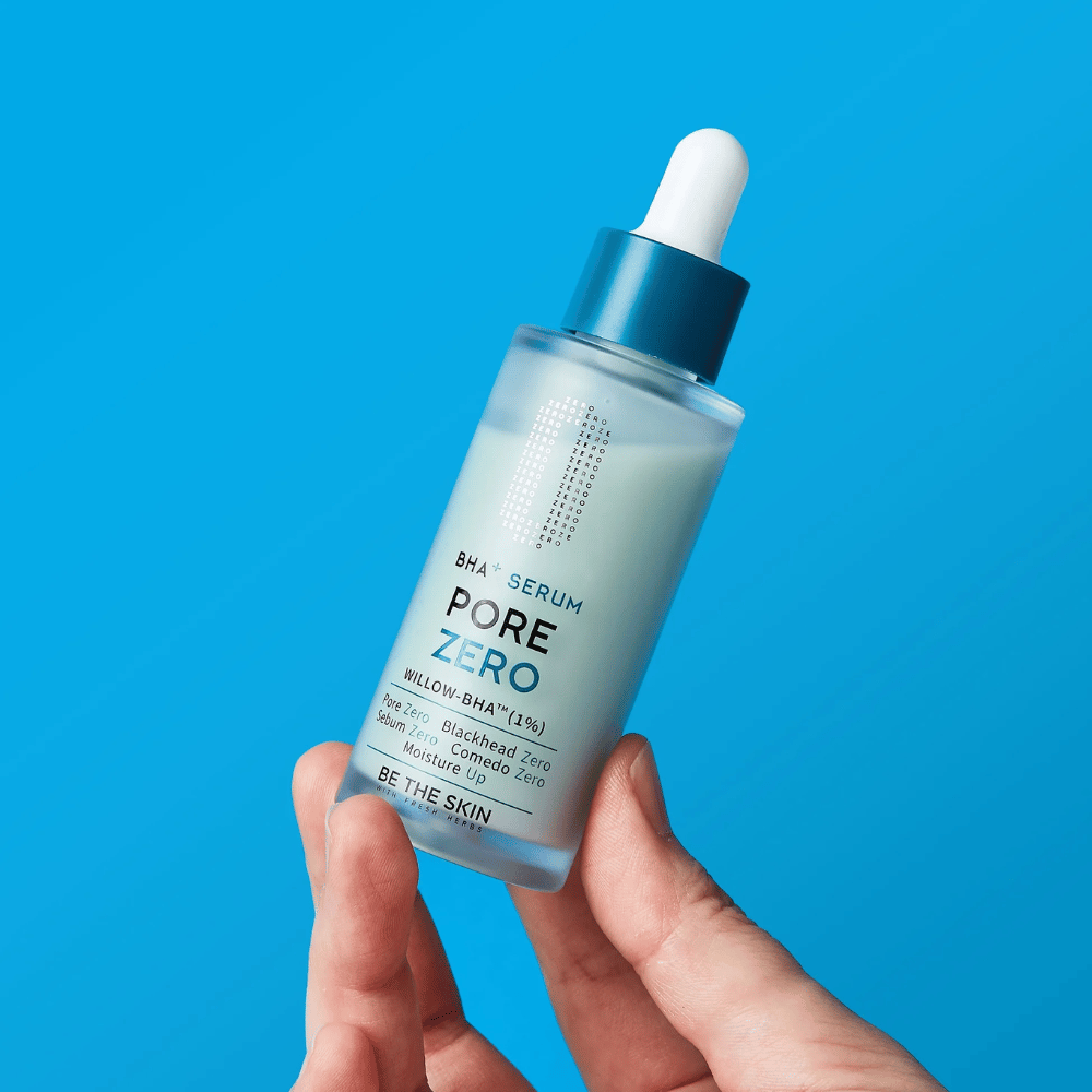 Be The Skin BHA+ Pore Zero Serum wird in der Hand vor blauem Hintergrund gehalten
