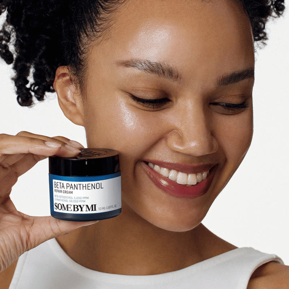 Modell mit strahlender Haut hält SOME BY MI Beta Panthenol Repair Cream – koreanische Gesichtscreme, die die Hautbarriere stärkt und Feuchtigkeit spendet.