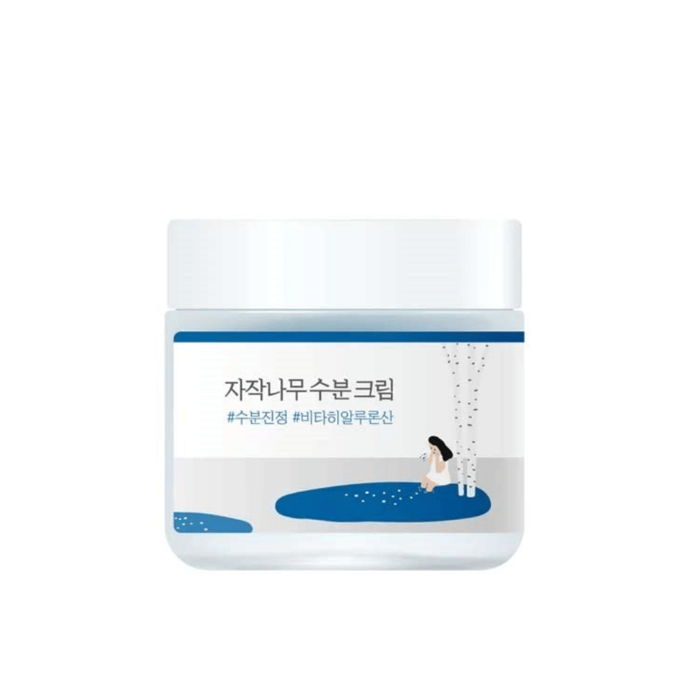 Round Lab Birch Juice Moisturizing Cream in einem transparenten Behälter mit weißem Deckel und blauem Etikett mit Illustration von Birke und Mädchen, freigestellt vor weißem Hintergrund.