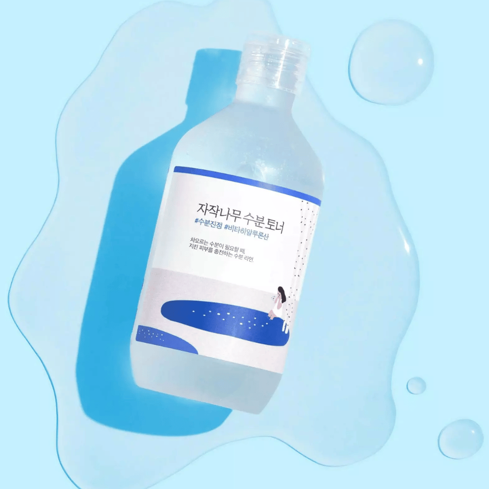 Die Flasche liegt schräg in einer wasserähnlichen Flüssigkeit mit Tropfen rundherum auf blauem Hintergrund