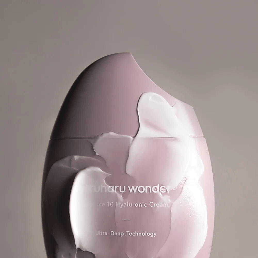 Das Bild zeigt ein Glas mit "Haruharu Wonder Black Rice 10 Hyaluronic Cream", das teilweise von einer dicken, durchsichtigen Creme bedeckt ist. Der Text im Bild deutet auf die Verwendung fortschrittlicher Technologie für tiefe Hautfeuchtigkeit hin. Das Design ist modern und minimalistisch.