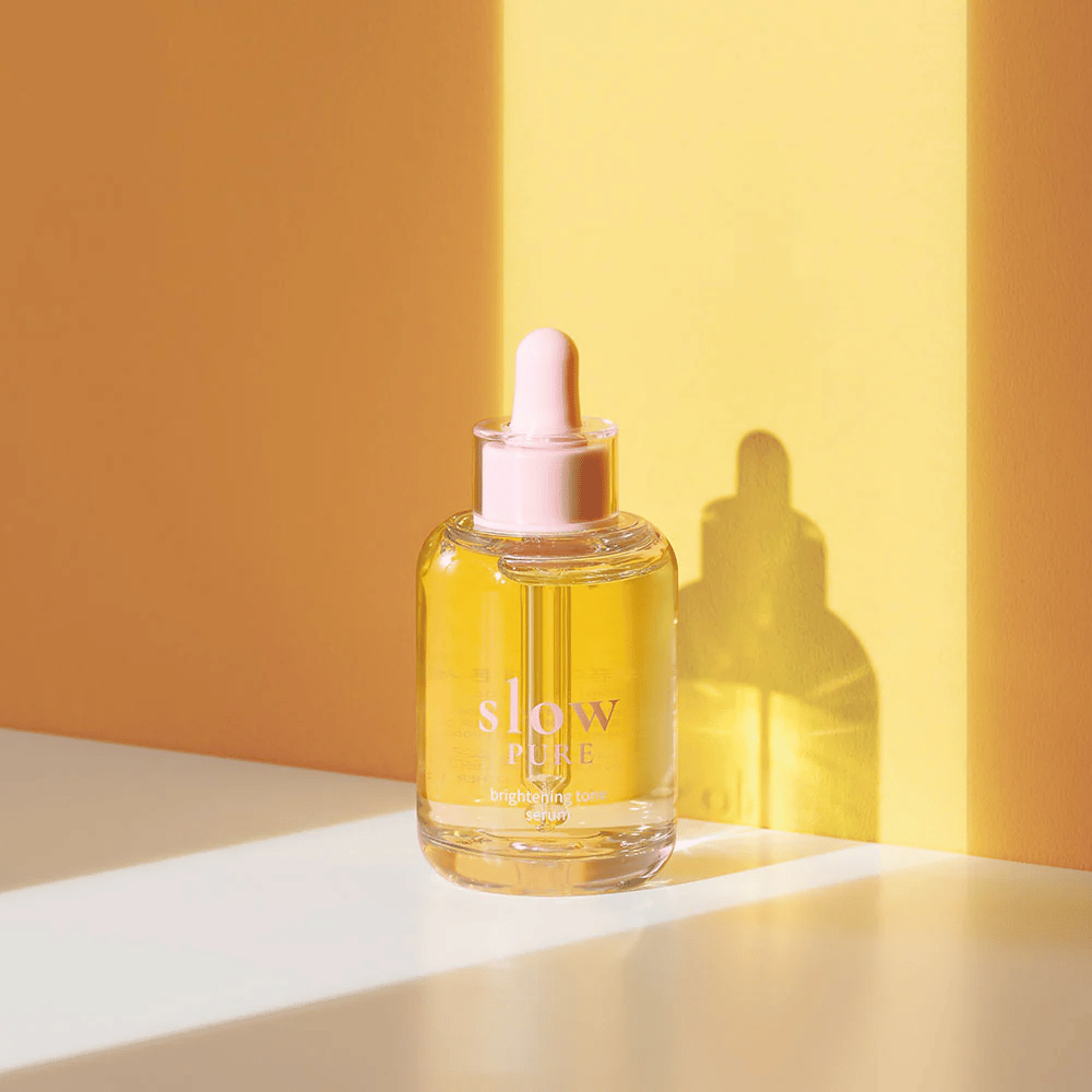 Slow Pure Brightening Tone Serum im sonnigen gelben Licht, symbolisiert Ausstrahlung und Energie für die Haut.
