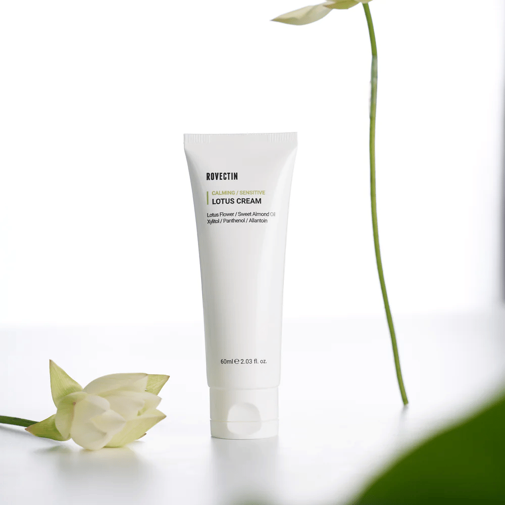 Tube mit Rovectin Lotuscreme für beruhigende und empfindliche Hautpflege, präsentiert mit einer Lotusblume.