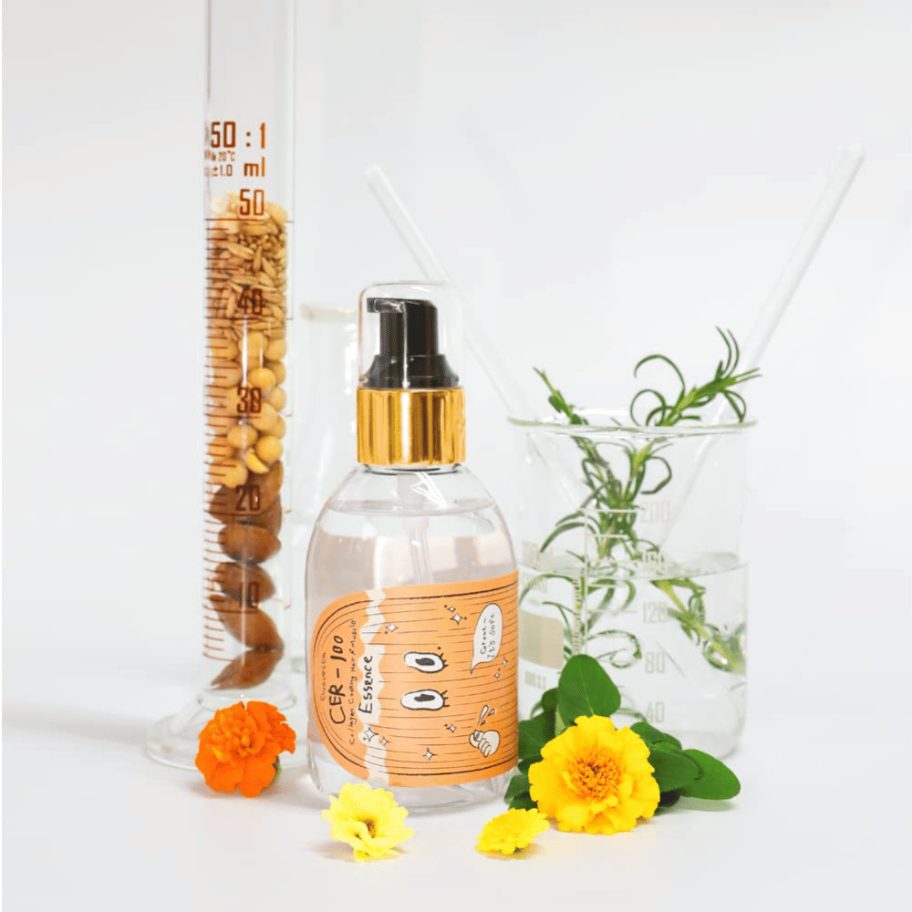 CER-100 Hair Essence zusammen mit Blumen und Laborglas, die die Inhaltsstoffe und Haarpflege hervorheben.