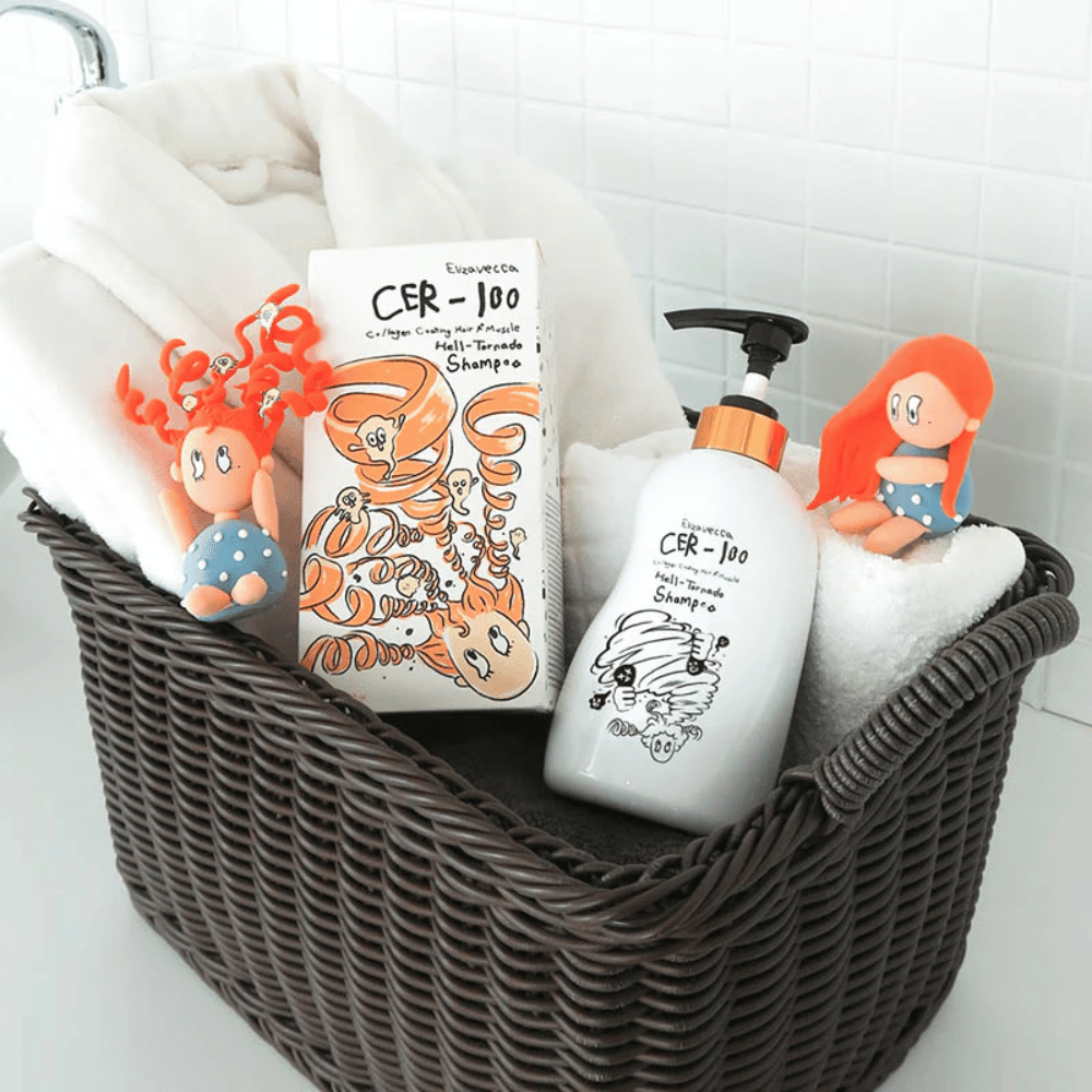 Präsentationsbild mit Elizavecca CER-100 Shampoo und Produktverpackung, die zusammen mit Handtüchern in einem Korb platziert sind. Verspielte Figuren aus dem Verpackungsdesign unterstreichen den einzigartigen und kreativen Stil der Marke.