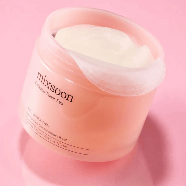 Mixsoon Collagen Toner Pad med 110 pads i en rosa burk, fotograferad mot en rosa bakgrund.