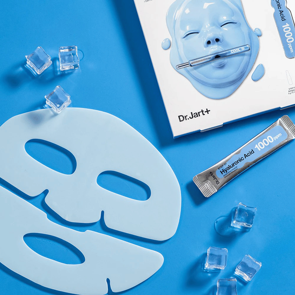 Dr.Jart+ Cryo Rubber Moisturizing Mask mit zweiteiliger blauer Gummimaske, Eiswürfeln, Hyaluronsäure-Ampulle und Verpackung vor blauem Hintergrund.