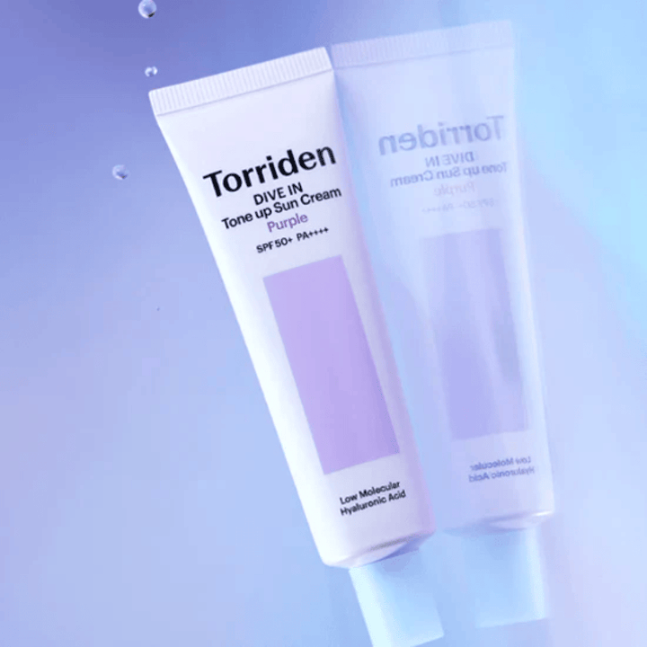Torriden DIVE IN Tone Up Sun Cream Purple SPF50+ PA++++ vor weichem lila Hintergrund fotografiert, der das lichtreflektierende Design des Produkts hervorhebt.