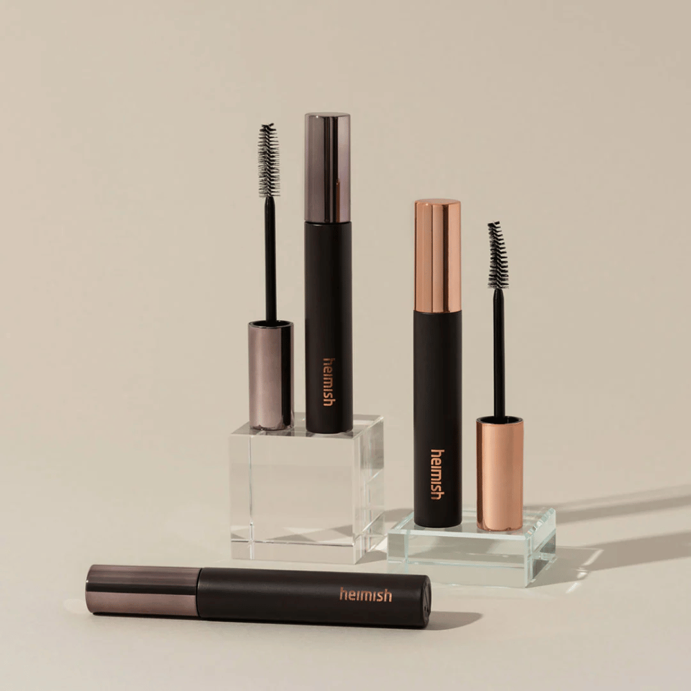 Heimish Dailism Smudge Stop Mascara mit sichtbaren Bürsten, die den Unterschied zwischen Volumen- und Curlingbürste zeigen.