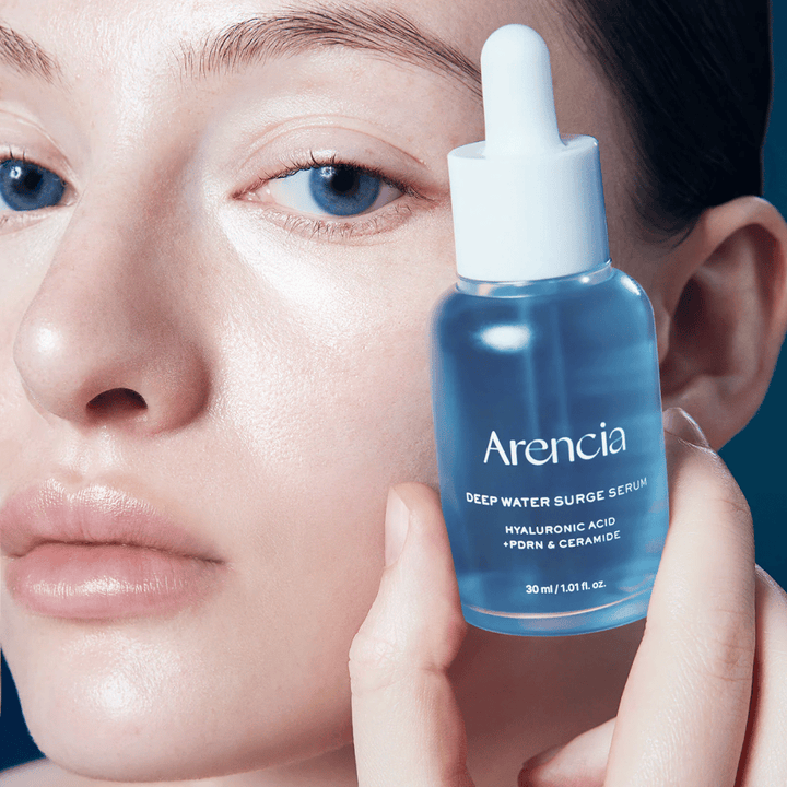 Modell appliziert Arencia Deep Water Surge Serum – feuchtigkeitsspendendes koreanisches Serum mit Hyaluronsäure, PDRN und Ceramiden, das empfindliche Haut beruhigt und die Hautbarriere stärkt.