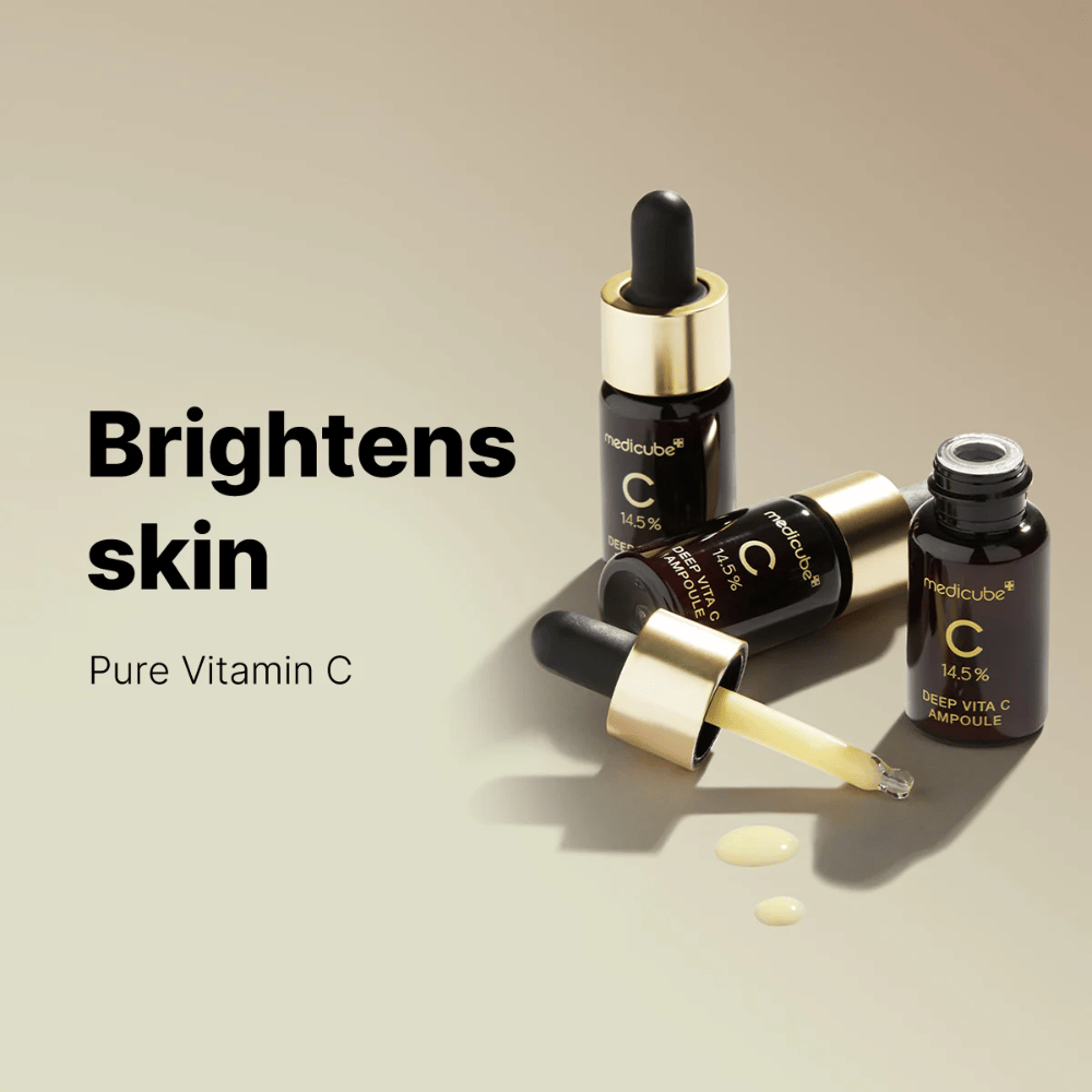Medicube Deep Vita C Ampoule mit 14,5 % Vitamin C, präsentiert in eleganten Flaschen mit goldfarbenen Pipetten. Das Produkt ist dafür entwickelt, den Hautton aufzuhellen und einen strahlenden Teint zu verleihen. Der Text "Brightens skin" und "Pure Vitamin C" verstärkt die Botschaft.