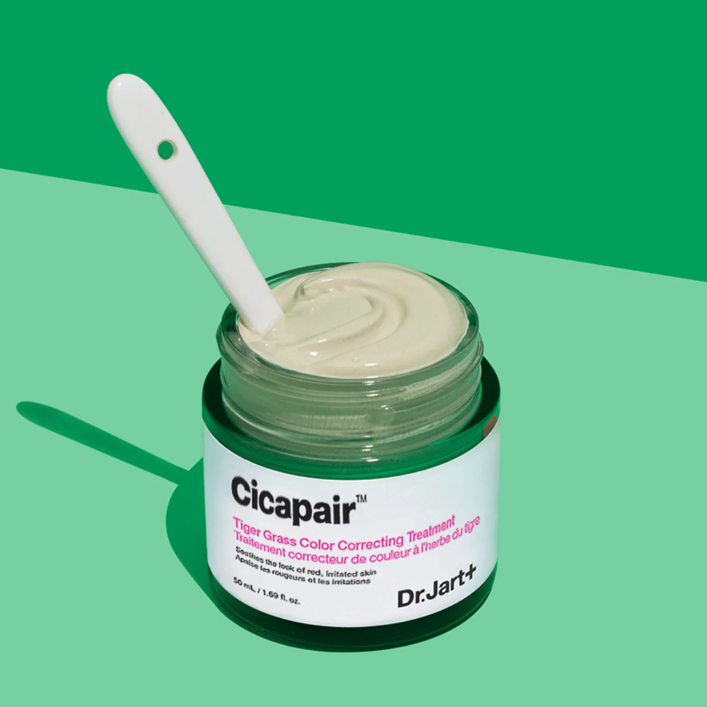 Ein Glas Cicapair Tiger Grass Color Correcting Treatment 50ml von Dr Jart+ auf grünem Hintergrund.