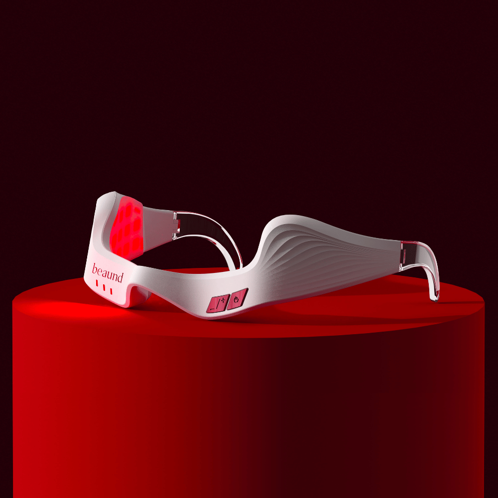 Produktbild, das Beaund Eye Rejuv mit aktiver roter LED-Beleuchtung zeigt, auf einem Podest platziert für ein exklusives und innovatives Gefühl.