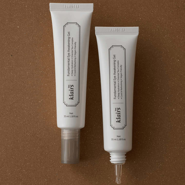 Produktbild, das Klairs Fundamental Eye Awakening Gel in zwei Ausführungen zeigt – eine geschlossene Tube und eine offene Tube, die die schmale Applikatorspitze hervorhebt. Die Verpackung hat ein minimalistisches weißes Design und betont den Fokus des Produkts auf Feuchtigkeit, kühlendes Gefühl und erfrischende Pflege für die Augenpartie.