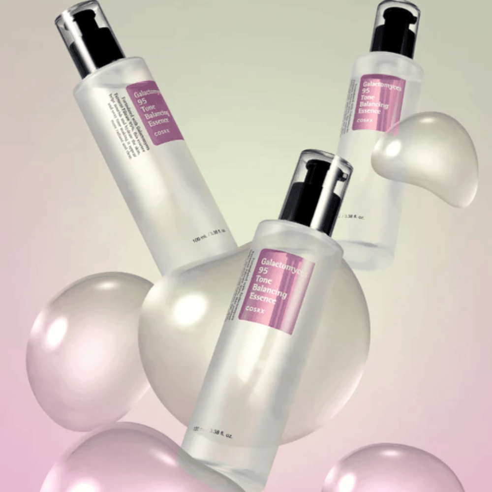 Drei Flaschen von COSRX Galactomyces 95 Tone Balancing Essence umgeben von hellen Blasen. Hautverbessernde Essenz, die den Hautton ausgleicht und natürlichen Glanz verleiht.