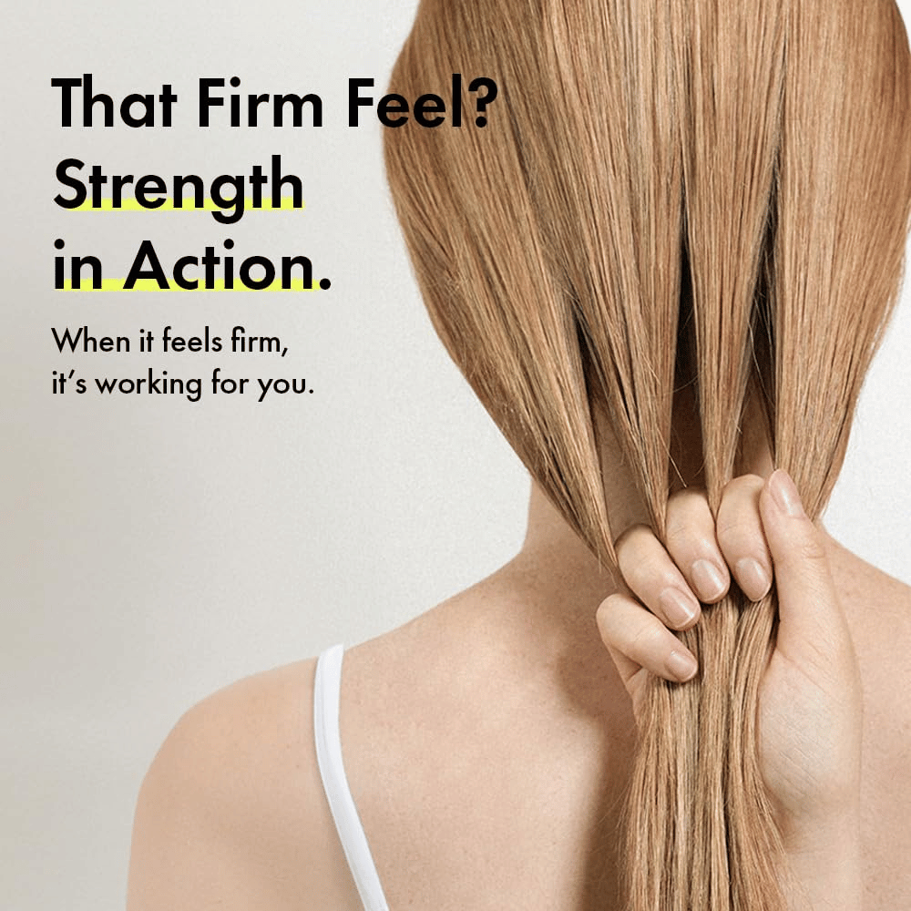 Person hält ihr Haar in der Hand, um stärkere Haarsträhnen und ein festeres Haargefühl nach der Anwendung von Grabity g0.0 Hair Lifting Shampoo Strong zu veranschaulichen.