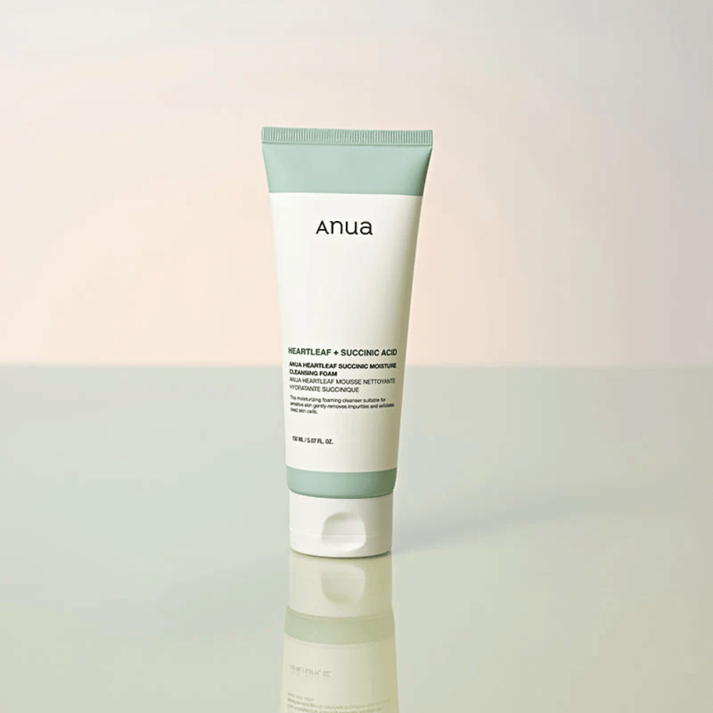 Freistehendes Produktbild von Anua Heartleaf + Succinic Acid Moisture Cleansing Foam. Das Produkt wird auf einer reflektierenden Oberfläche stehend gezeigt, die das Design der Verpackung und die stilvolle Ästhetik der Marke deutlich hervorhebt.