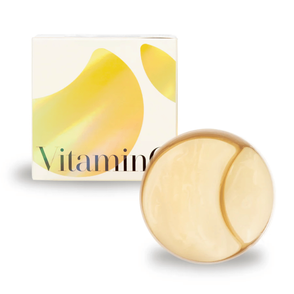 K-Secret Extra Illuminating Eye Gel Patches mit Vitamin C in goldschimmerndem Hydrogel, Dose und Verpackung im Hintergrund.