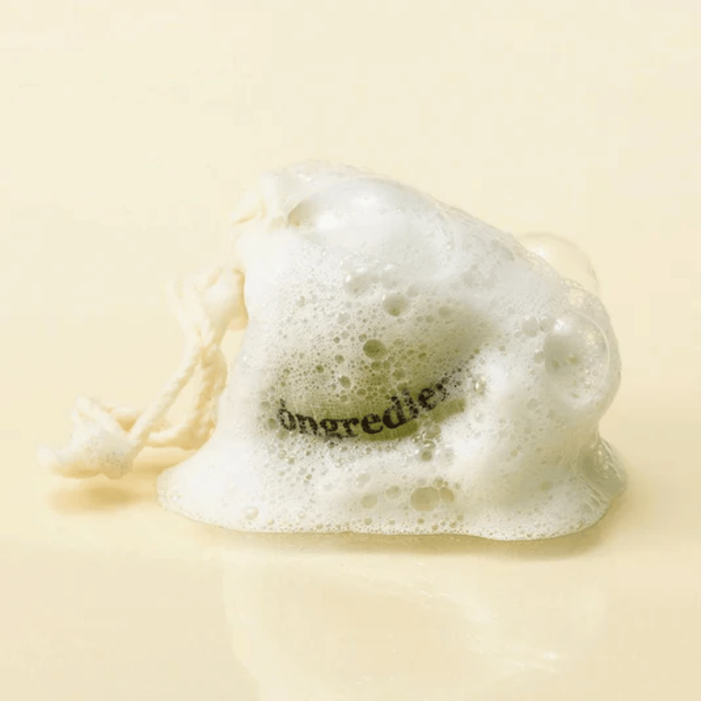 Óngredients Jeju Green Tea Cleansing Ball in einem Netzbeutel, bedeckt mit weichem Schaum – natürliche koreanische Gesichtsseife.