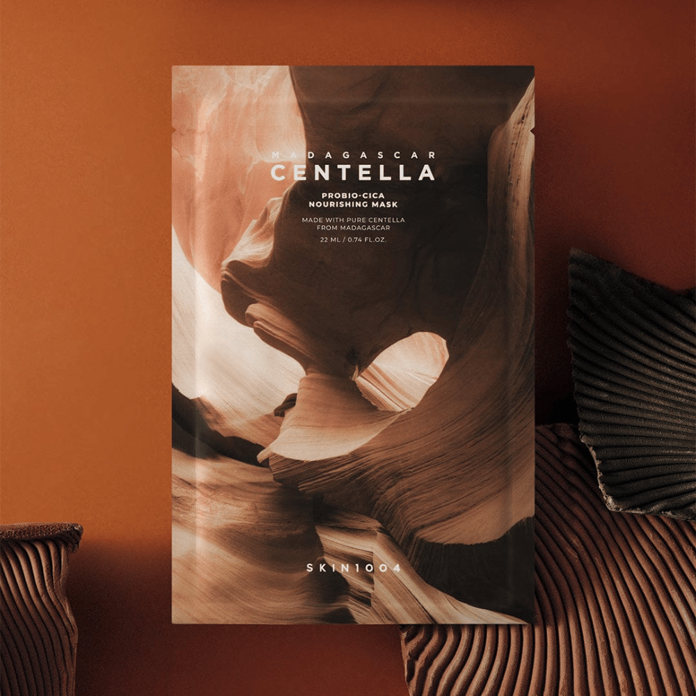 Sheet mask-Verpackung von SKIN1004 vor warmbraunem Hintergrund mit naturinspiriertem Design.