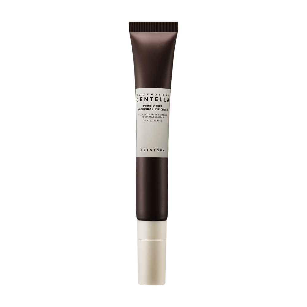 Eine Tube von "Madagascar Centella Probio-Cica Bakuchiol Eye Cream" von SKIN1004. Das Produkt ist für den Augenbereich konzipiert und enthält Inhaltsstoffe wie Centella aus Madagaskar und Bakuchiol, bekannt für ihre hautpflegenden und feuchtigkeitsspendenden Eigenschaften. Die Tube ist elegant mit einer dunkelbraunen Farbe, die in Weiß übergeht.