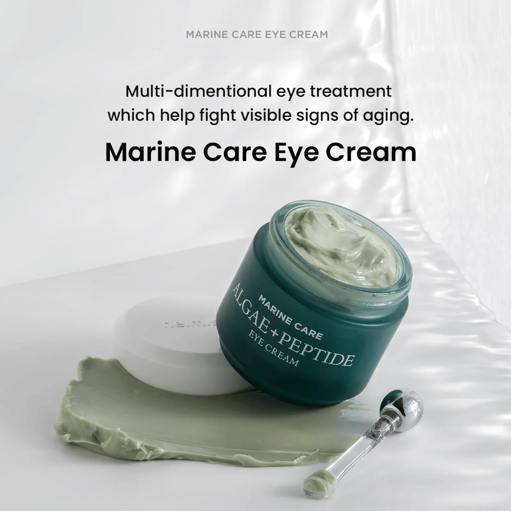 Heimish Marine Care Algae + Peptide Eye Cream in einem offenen Behälter mit grünlicher Creme. Die Creme ist neben dem Behälter verteilt und ein Applikator liegt daneben. Das Produkt bekämpft Anzeichen der Hautalterung und bietet intensive Feuchtigkeit.