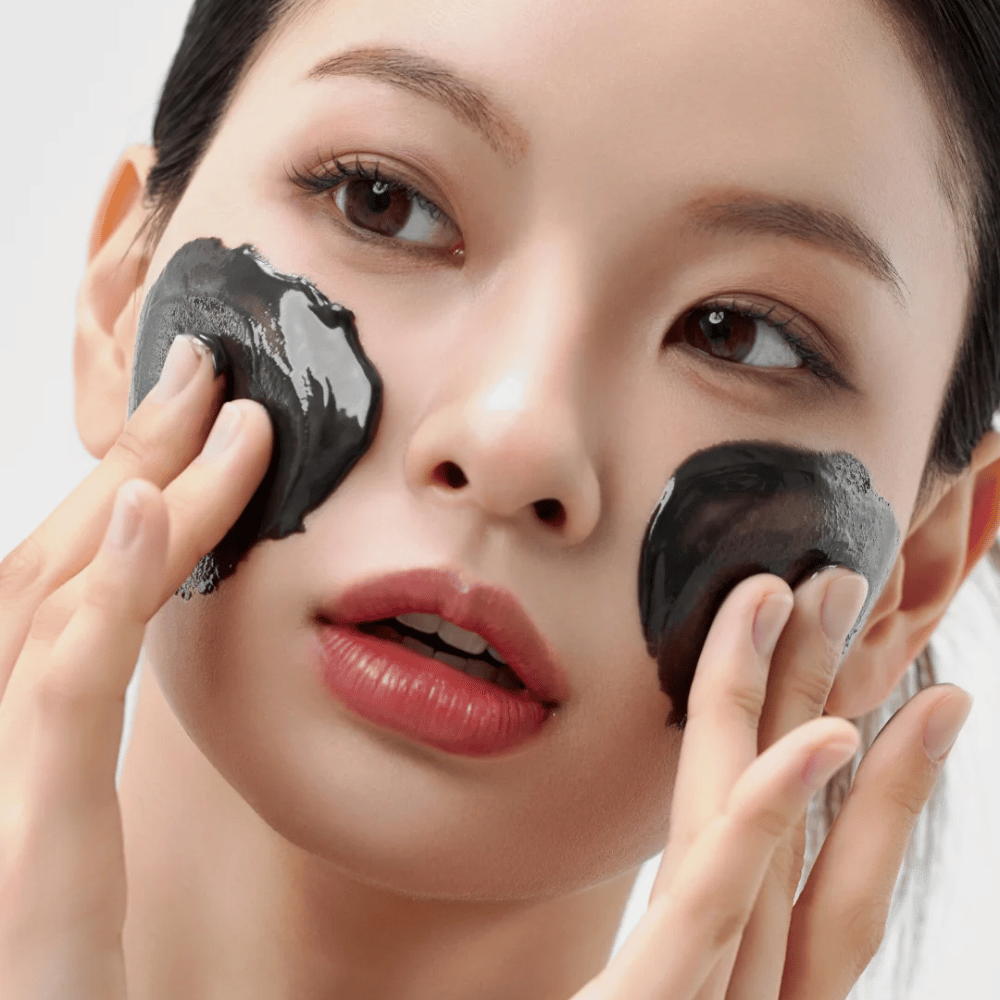 Nahaufnahme der Anwendung von Wie Midnight Soothing Cleansing Balm im Gesicht. Weicher Reinigungsbalsam, der Unreinheiten auflöst und ein beruhigendes Hautgefühl verleiht.