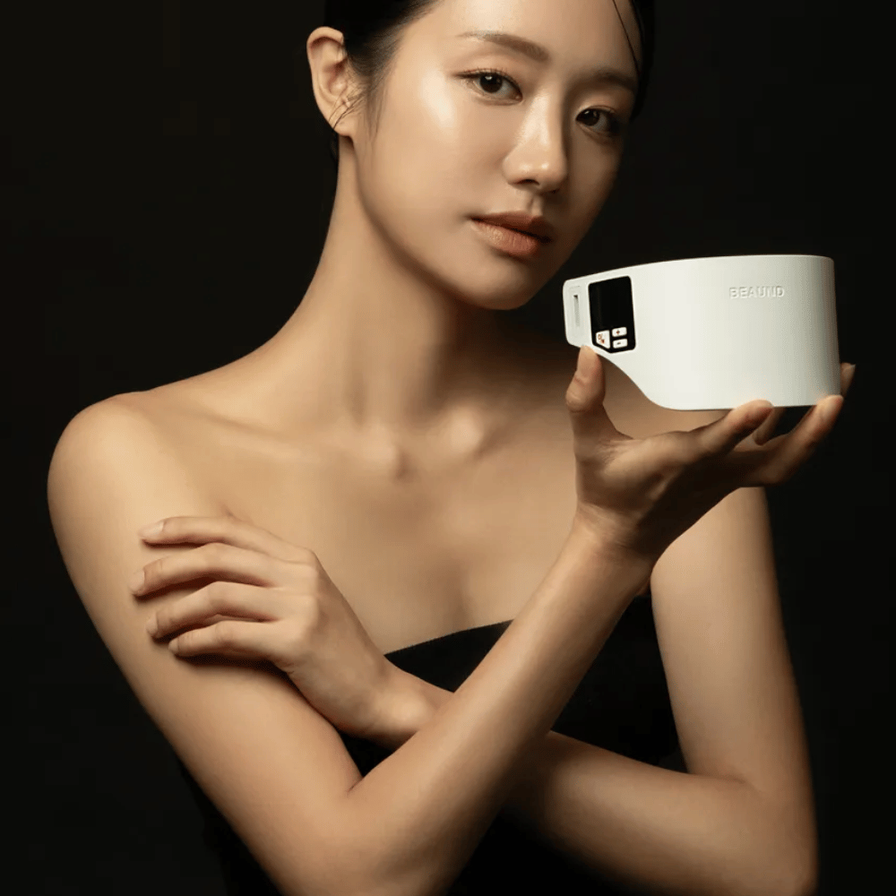 Ein Modell hält Beaund Neckcera in der Hand vor einem dunklen Hintergrund. Das Bild hebt das elegante Design und die Premium-Anmutung des Produkts hervor.