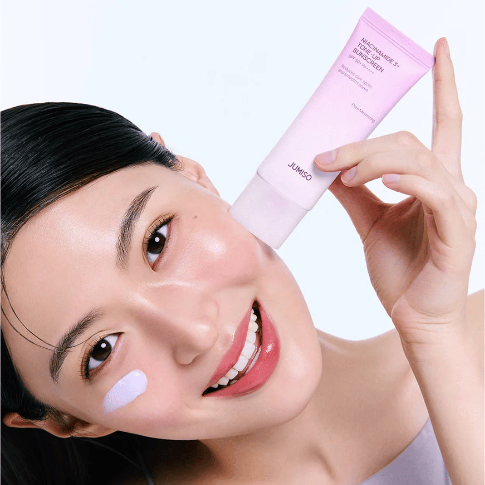 Das Model trägt JUMISO Niacinamide 3+ Tone-Up Sunscreen SPF50+ PA++++ für UV-Schutz, einen ebenmäßigeren Hautton und natürliche Ausstrahlung auf.