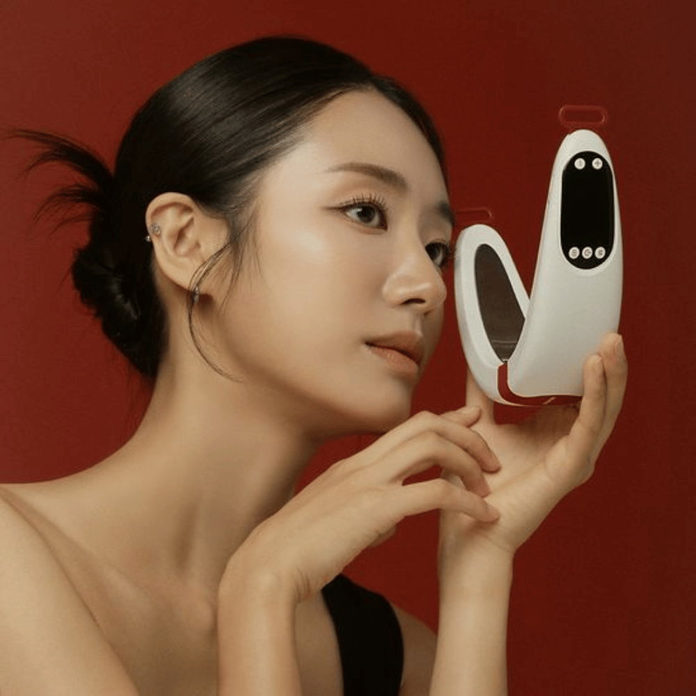 Ein Model hält Beaund Nmode Pro vor das Gesicht vor einem roten Hintergrund. Das Bild hebt das elegante Design, das digitale Display und das kompakte Format des Geräts hervor.