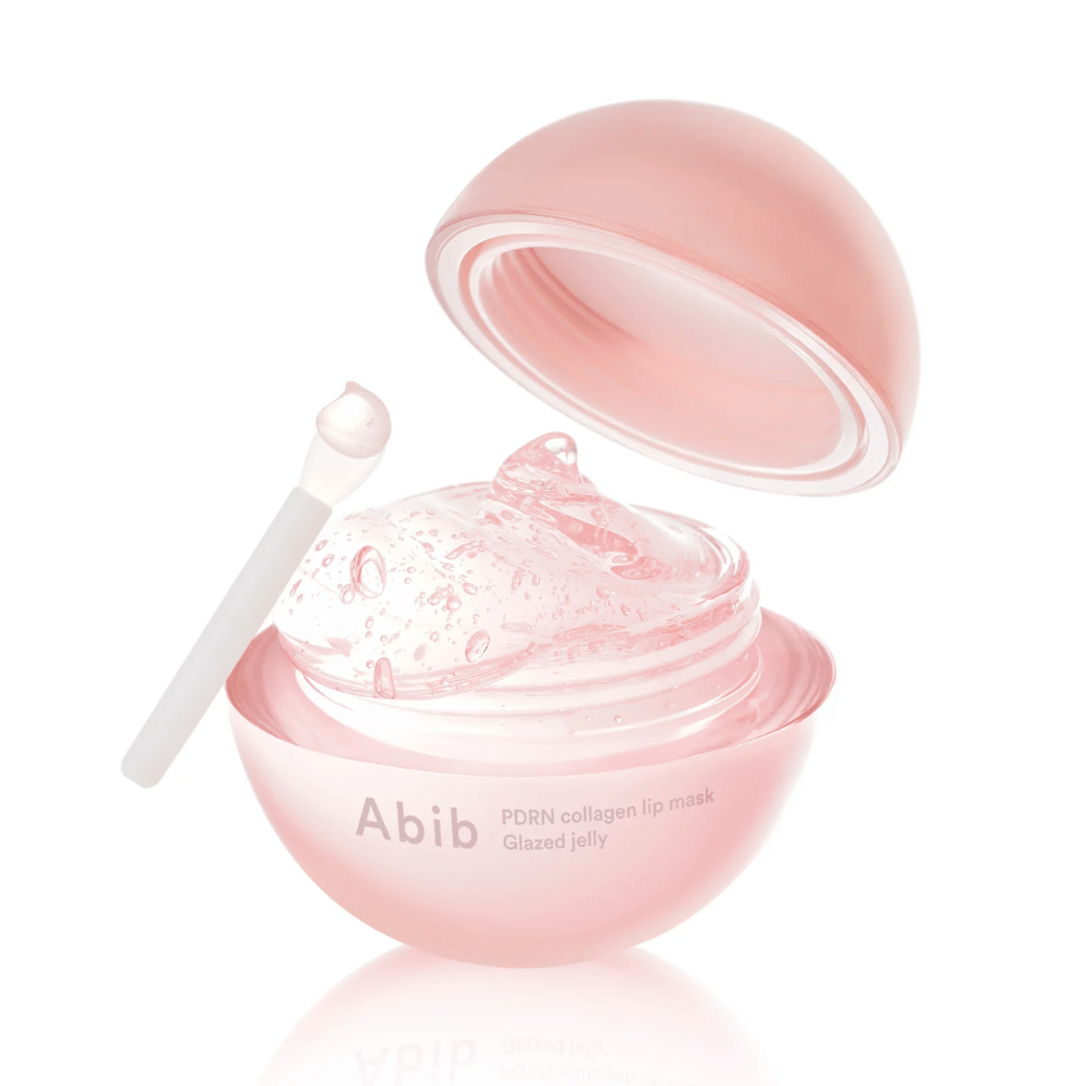 Rosa runde Dose mit Abib PDRN Collagen Lip Mask Glazed Jelly, offen mit nach hinten geneigtem Deckel. Durchsichtiges Gel mit Luftblasen ist in der Dose zusammen mit einem kleinen Spatel zu sehen.