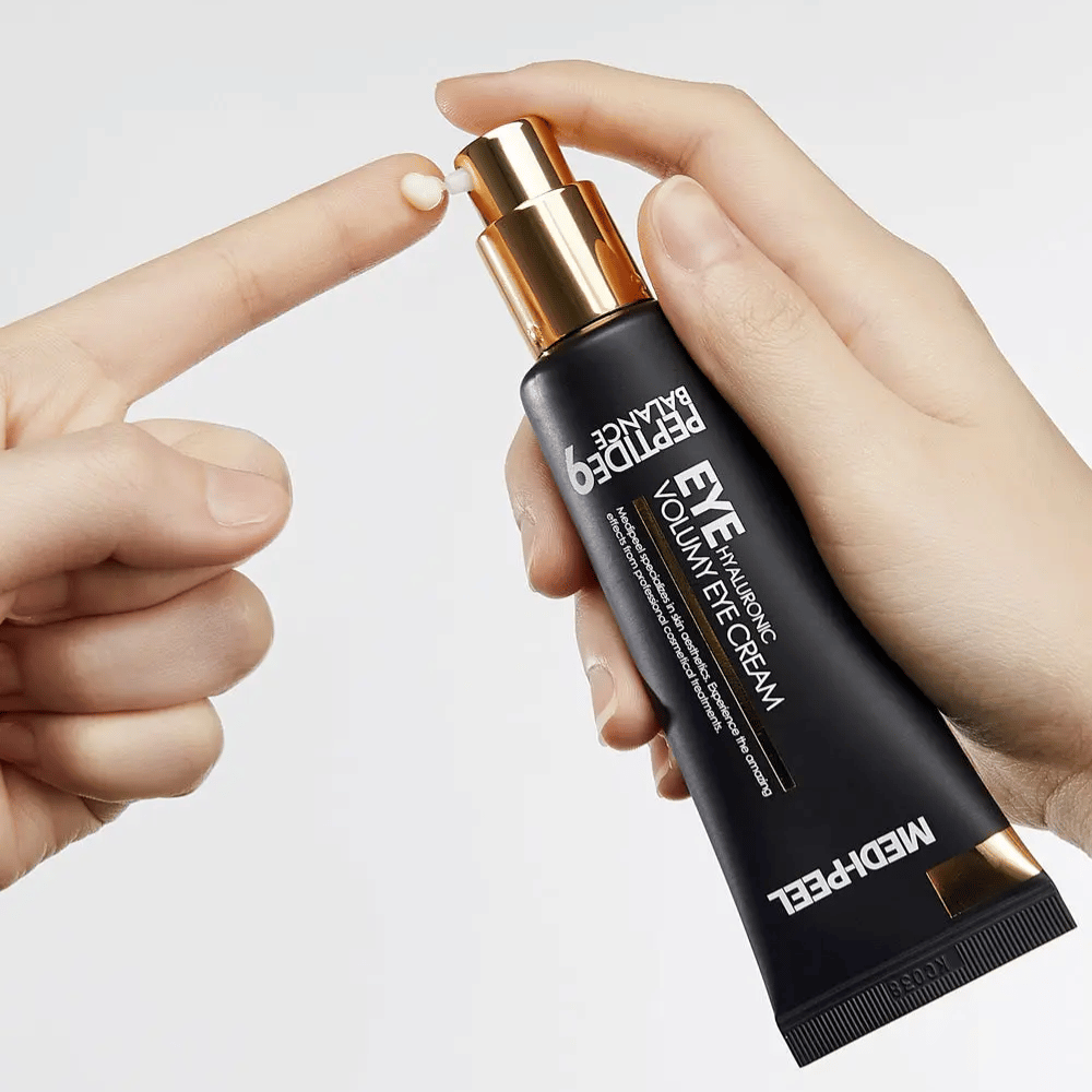 Anwendung von MEDI-PEEL Peptide 9 Hyaluronic Volumy Eye Cream auf der Fingerspitze – feuchtigkeitsspendende Augencreme mit Peptidkomplex, die hilft, feine Linien zu reduzieren und aufgepolsterte Haut zu verleihen.