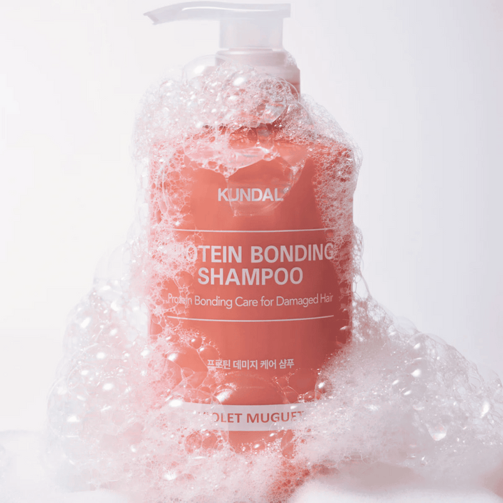 KUNDAL Protein Bonding Shampoo Violet Muguet täckt av rikligt lödder, reparerande schampo för skadat hår.