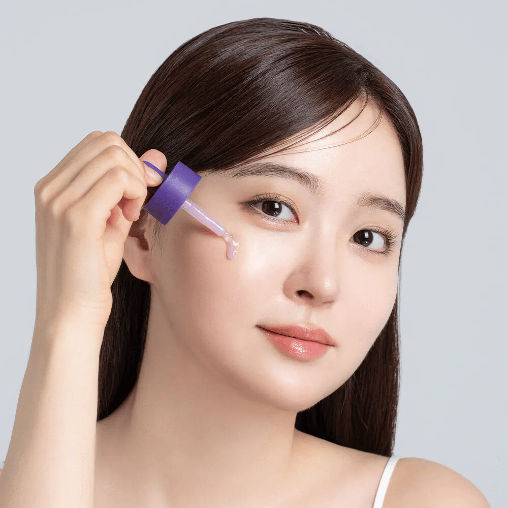 Anwendung von Cellology Purple Carrot Pore Ampoule mit Pipette im Gesicht für Porenpflege und ein ebenmäßigeres Hautbild.