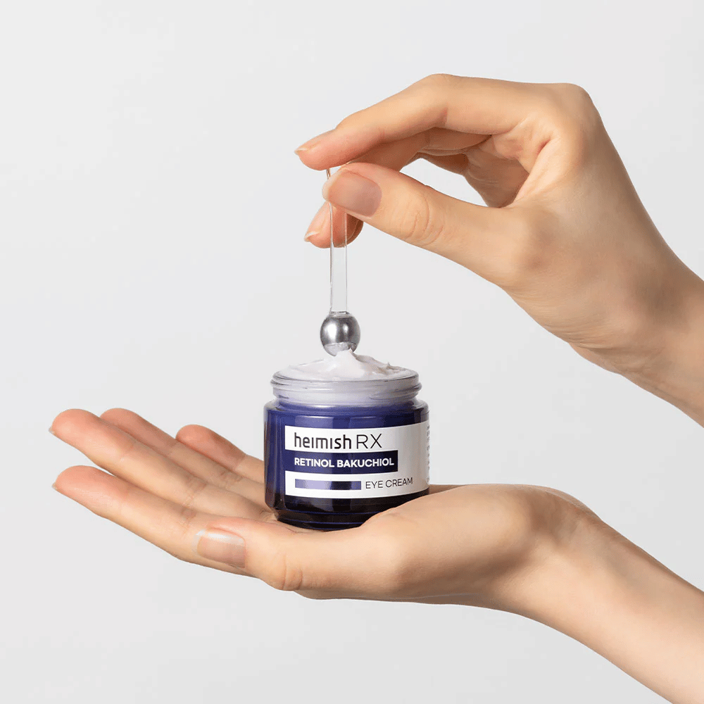 Heimish RX Retinol Bakuchiol Eye Cream in einem eleganten blauen Behälter, angehoben mit einem Metallapplikator. Eine Augencreme mit Retinol und Bakuchiol, um feine Linien zu reduzieren und eine straffere Haut zu verleihen.