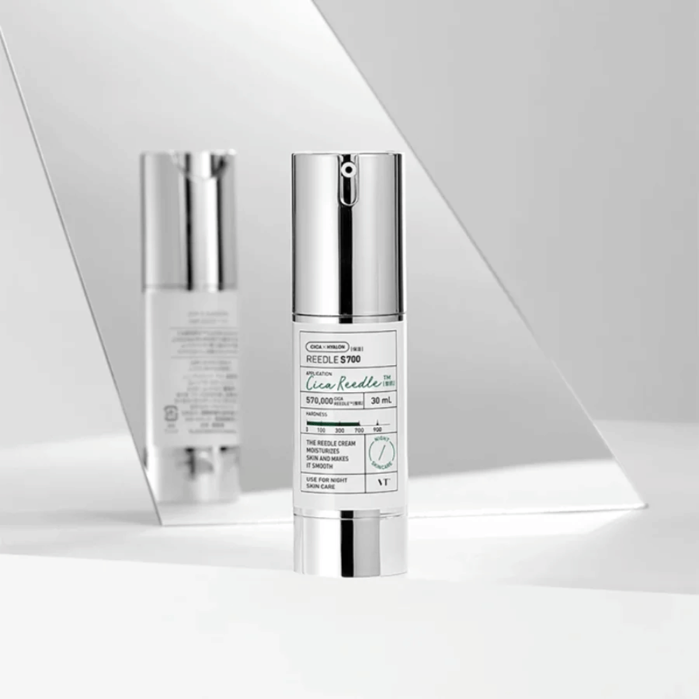 Reedle Shot 700 ist ein Hautpflegeserum in einer eleganten silber- und weißen Flasche. Es enthält 570.000 Cica Reedle, die dazu bestimmt sind, die Haut zu befeuchten und zu verfeinern. Das Produkt wird für die Nachtanwendung empfohlen und ist Teil der täglichen Hautpflegeroutine.