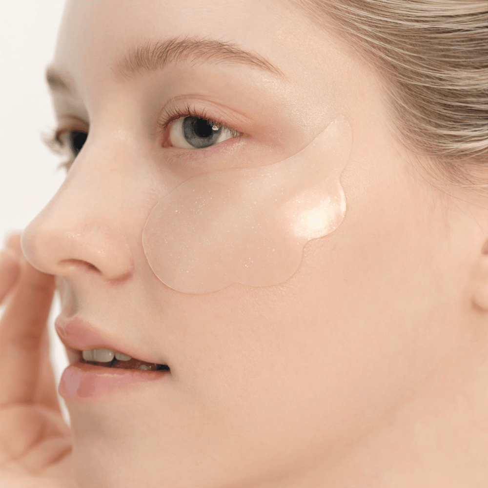 Nahaufnahme eines Modells, das Beauty of Joseon Under Eye Patch unter dem Auge für Feuchtigkeit, Ausstrahlung und straffende Wirkung aufträgt.