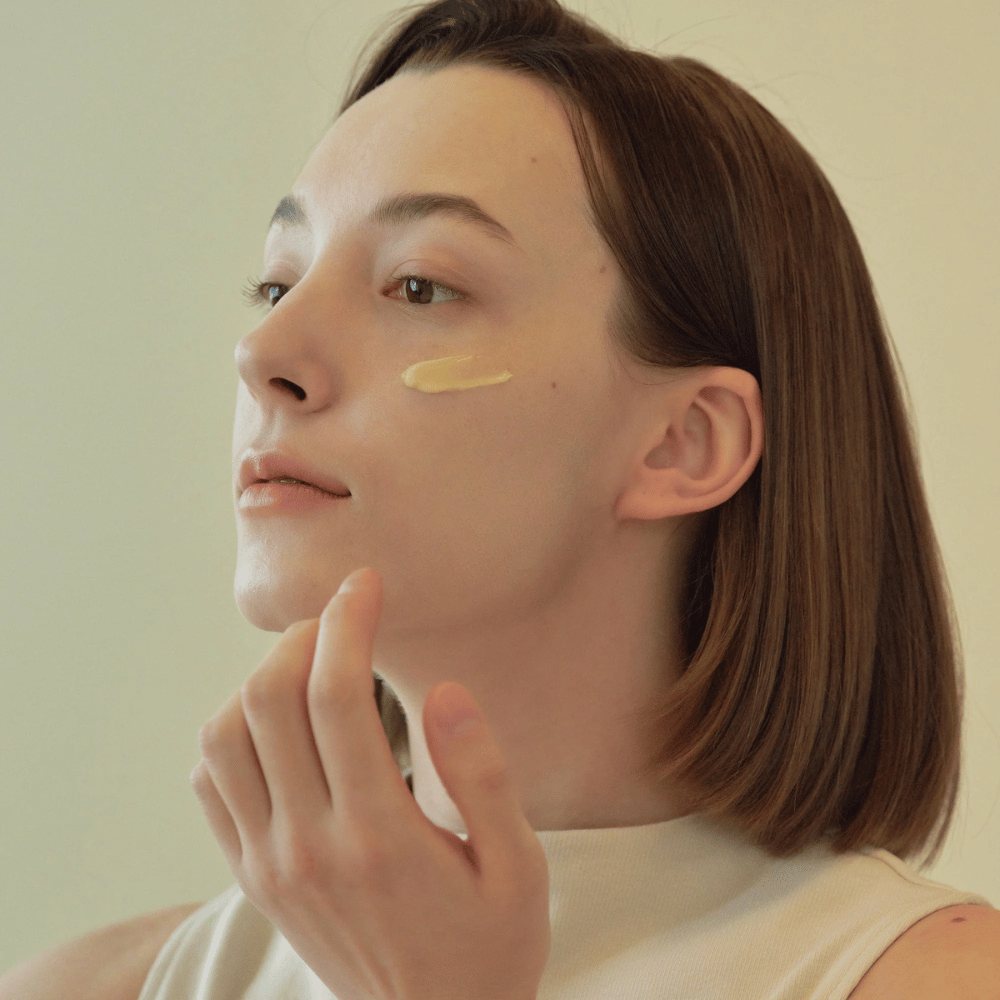 Bild eines Modells, das Beauty of Joseon Revive Eye Serum unter dem Auge aufträgt – Anti-Aging-Serum mit Ginseng und Retinal.
