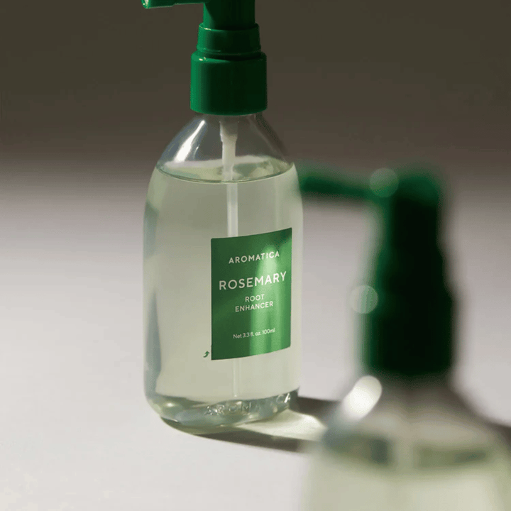 Nahaufnahme von AROMATICA Rosemary Root Enhancer mit grüner Applikatorspitze. Das Bild konzentriert sich auf das Design der Flasche und die präzise Anwendung direkt auf die Kopfhaut.