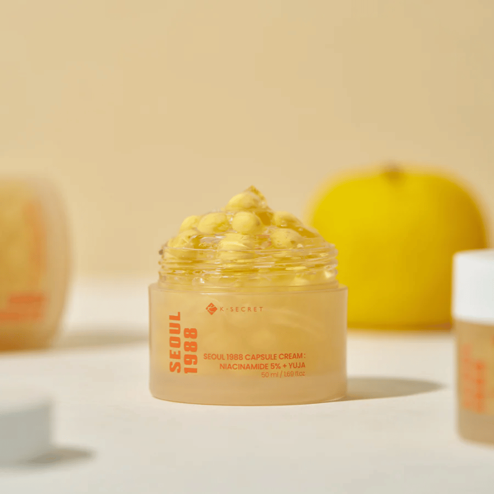 Offene Dose mit gelben Kapseln neben halbierter Yuja-Frucht, die die vitamin-C-reiche Formel hervorhebt.